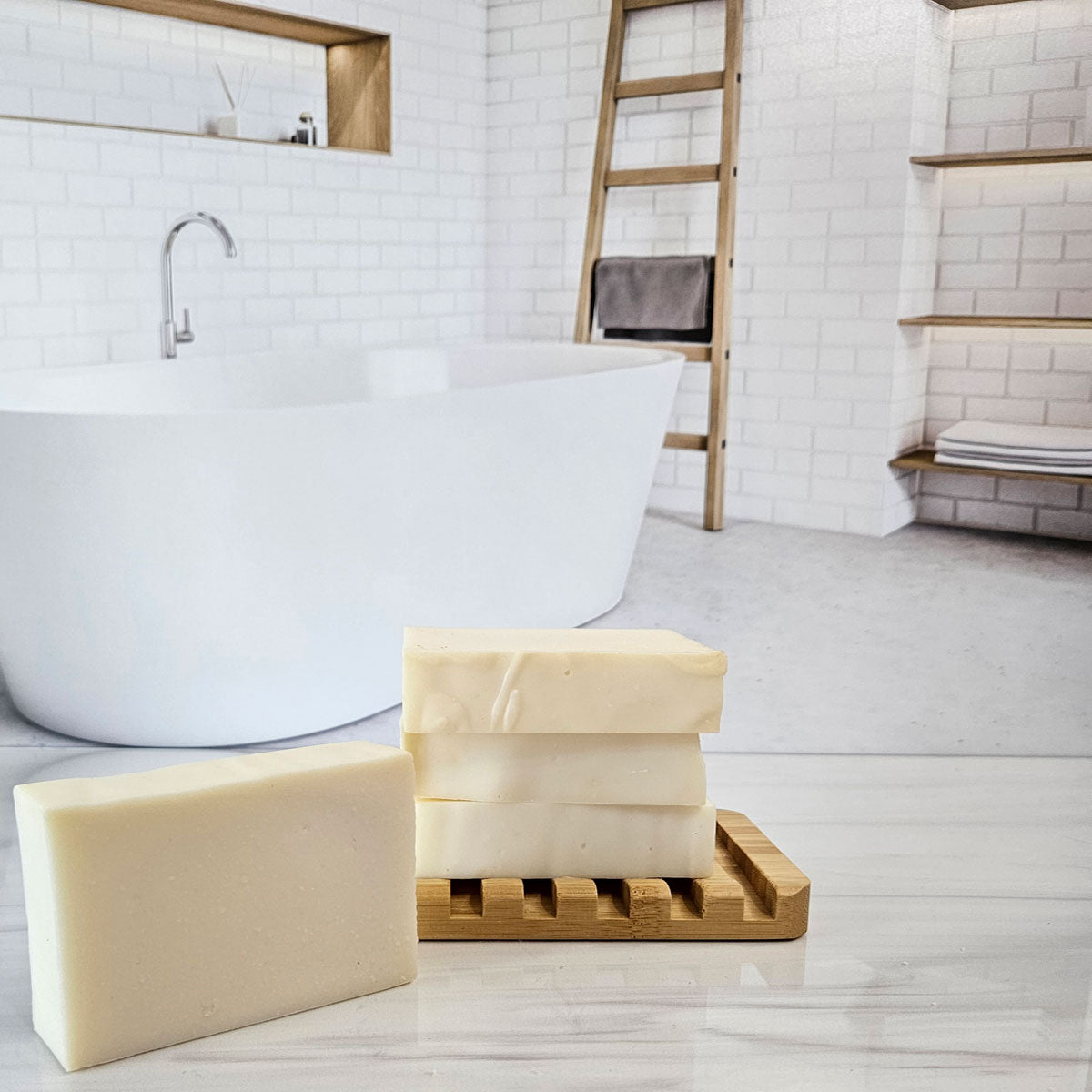 Handmade lavender castile soap bars, made with olive oil and lavender essential oil, on a wooden soap dish in a bathroom setting.