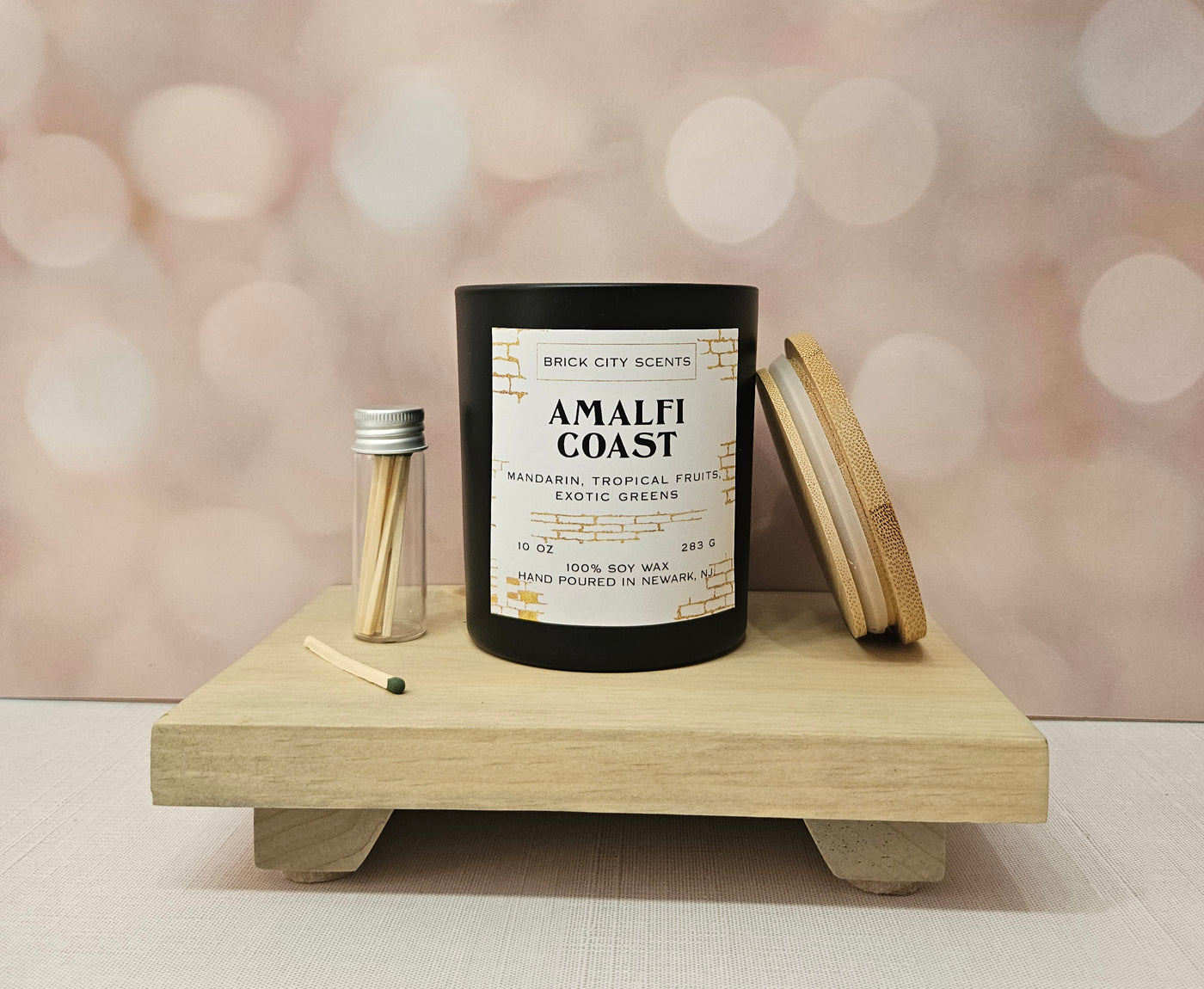 Brick City Scents Amalfi Coast candle in a black jar with matches and a bamboo lid.