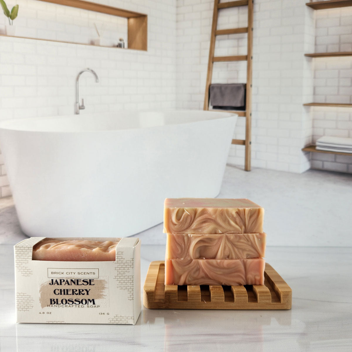 Brick City Scents Japanese Cherry Blossom handcrafted soap bars and boxed soap on a bamboo soap dish in a bathroom setting.