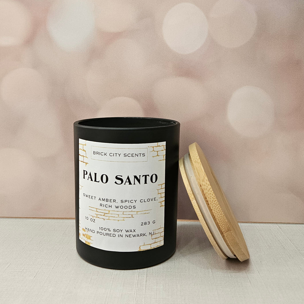 Brick City Scents Palo Santo candle in a black jar with a wooden lid. 10 oz soy wax candle, hand-poured in Newark, NJ.