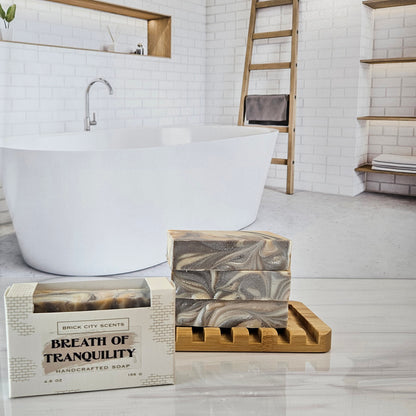 Brick City Scents Breath of Tranquility handcrafted soap bars stacked on a bamboo holder with recyclable packaging.